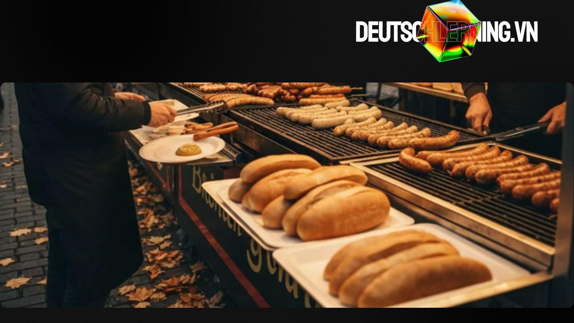 Đầu bếp nướng bratwurst trên bếp than trong lễ hội Oktoberfest.