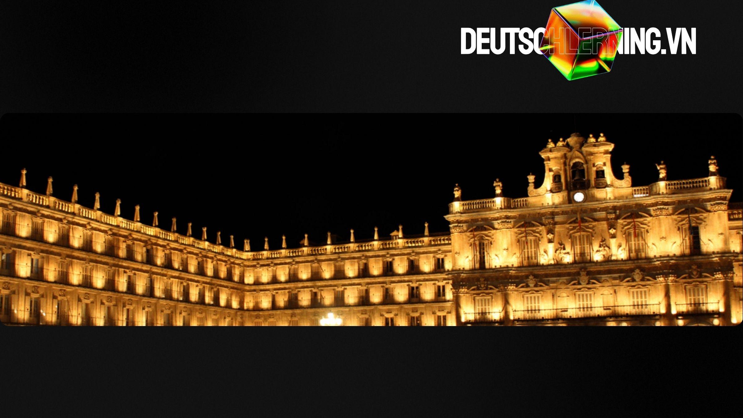 Quảng trường lịch sử ở Đức với ánh đèn vàng vào ban đêm.